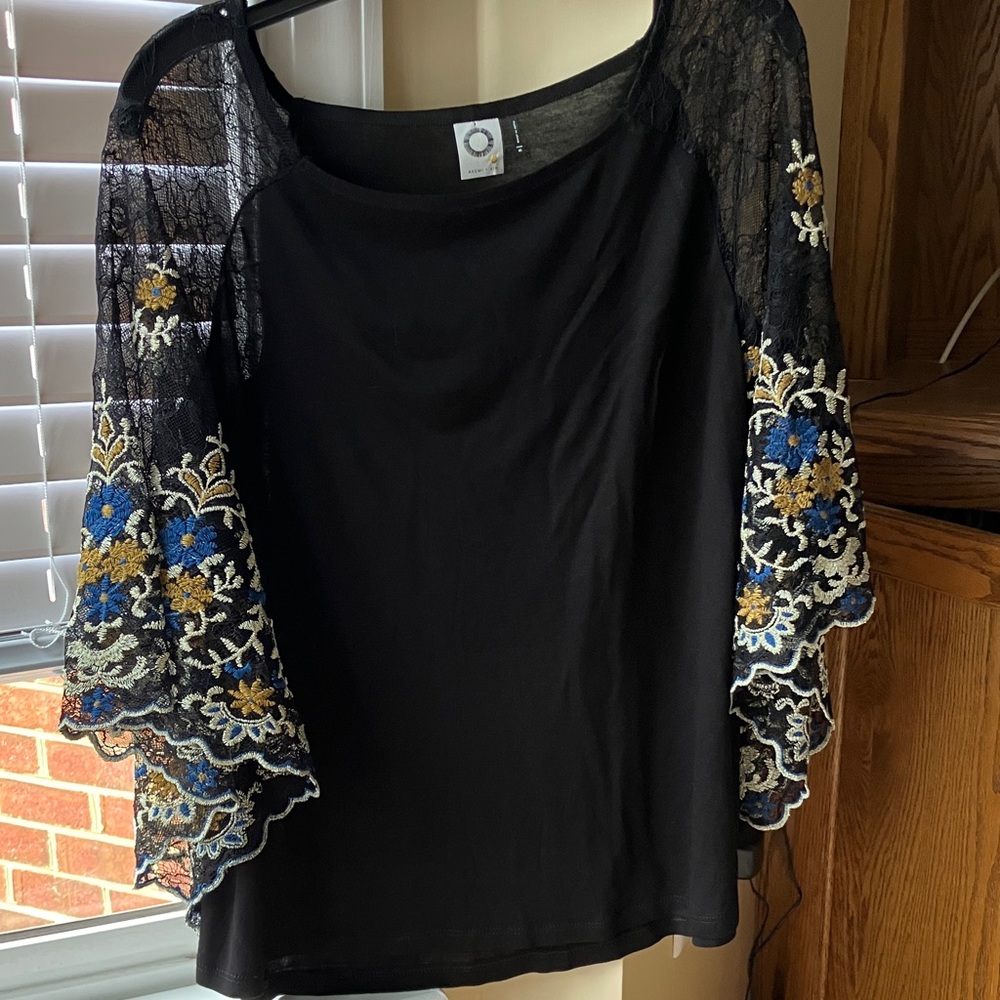 From Anthropologie. Beautiful black top 
With lacy sleeves of gold tan and blue